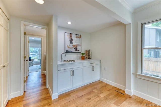 8167 S Wabash Ct, Centennial, CO 80112 - bar area featuring light wood-style flooring, ornamental molding, and recessed lighting