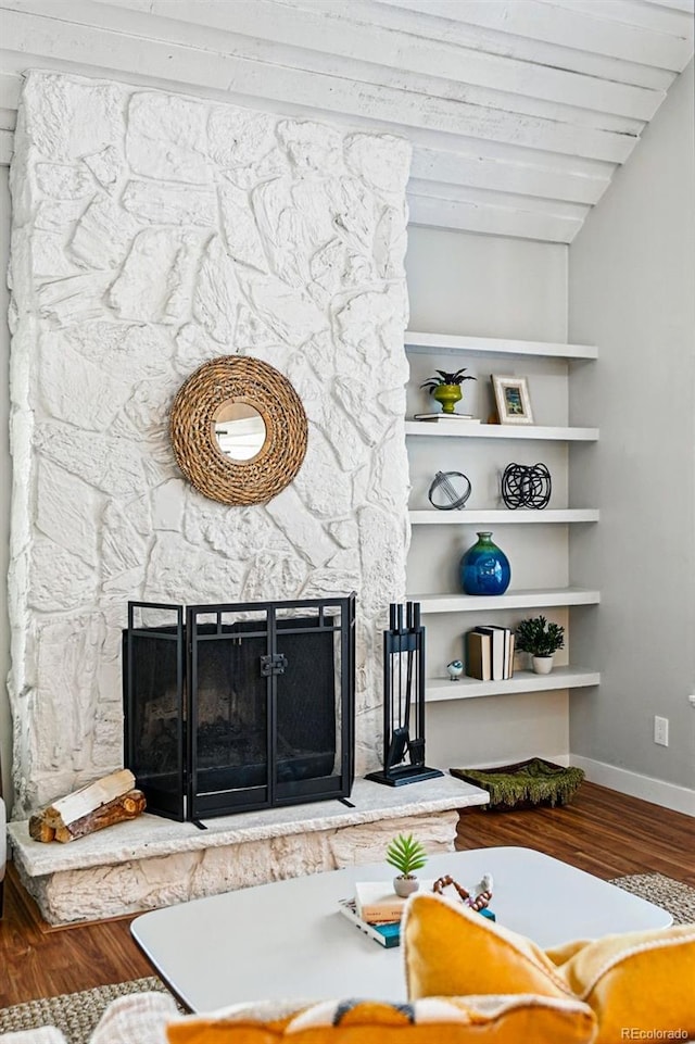 living area with a fireplace, wood finished floors, and baseboards