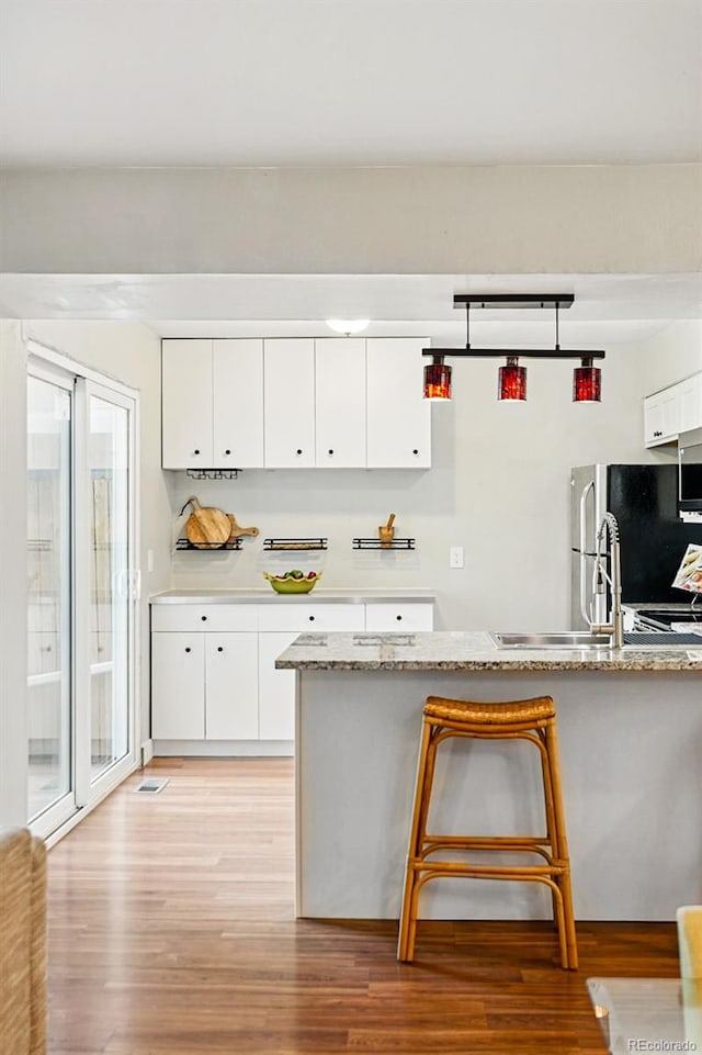 kitchen with light wood-style flooring and white cabinetry