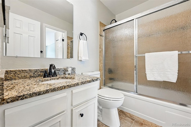 full bath with toilet, shower / bath combination with glass door, vanity, and tile patterned floors