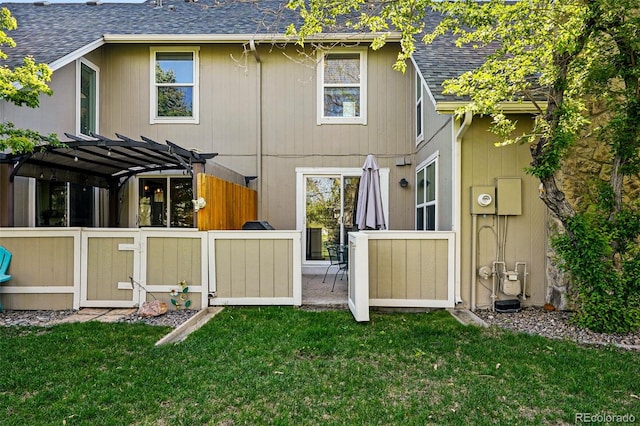 back of property with a shingled roof, a lawn, a pergola, and a patio