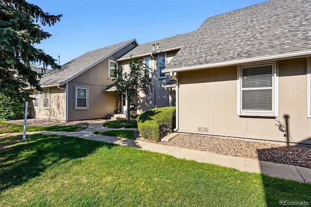 view of front of house with a front lawn and a shingled roof