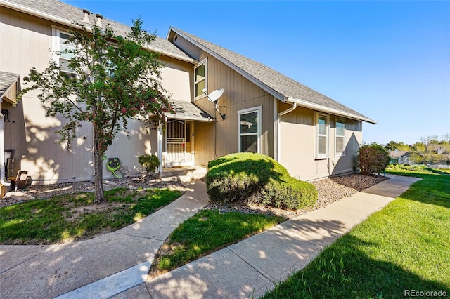 view of front of home featuring a shingled roof and a front lawn