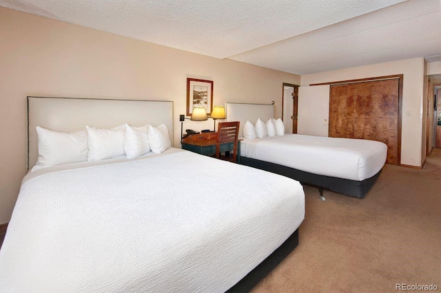 carpeted bedroom with a closet and a textured ceiling