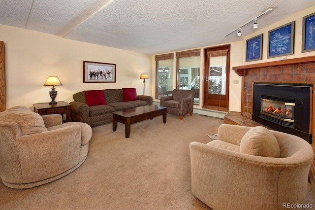 carpeted living room with rail lighting, a textured ceiling, and a baseboard heating unit