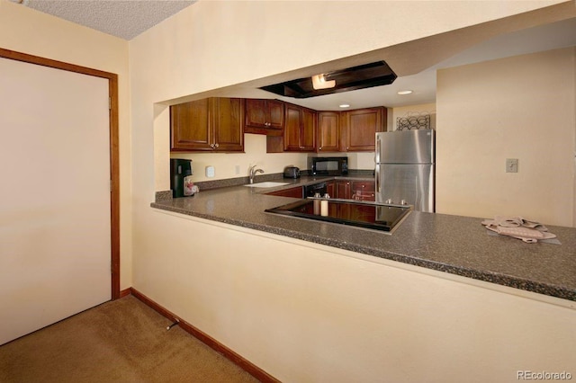 kitchen with carpet flooring, kitchen peninsula, black appliances, and sink