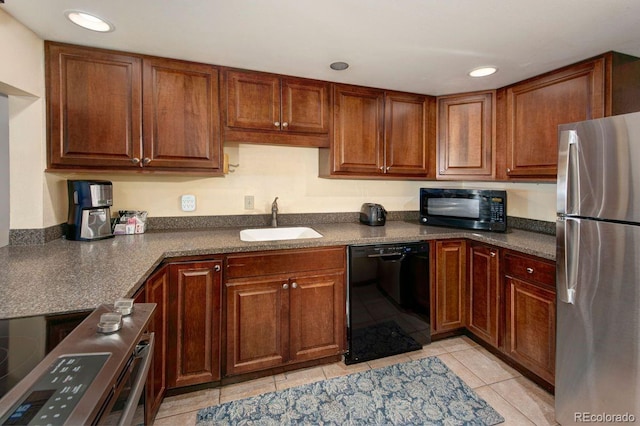 kitchen with light tile patterned floors, sink, and black appliances