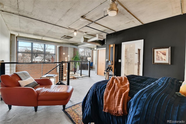 carpeted bedroom with connected bathroom and a wall mounted AC