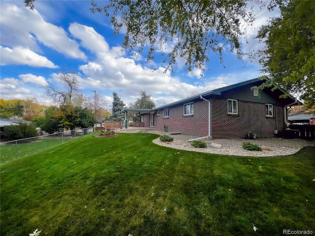 view of side of property featuring a yard and a patio area