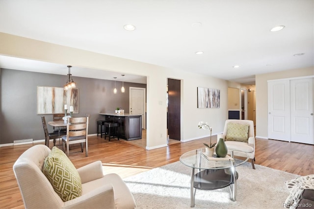 living room with a baseboard heating unit and light wood-type flooring