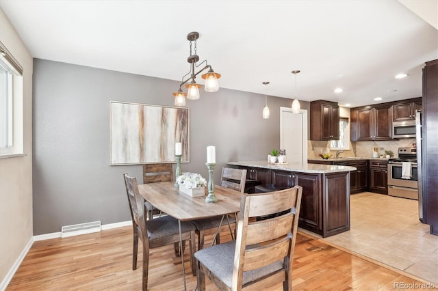 dining room with light wood-type flooring and sink