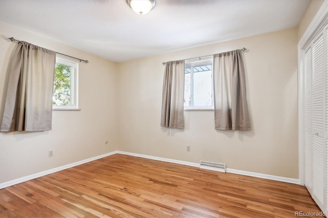 unfurnished bedroom featuring a closet and light hardwood / wood-style floors