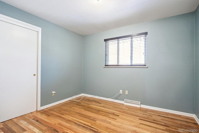 unfurnished room with hardwood / wood-style flooring