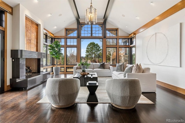 living area with wood-type flooring, a premium fireplace, baseboards, and a notable chandelier