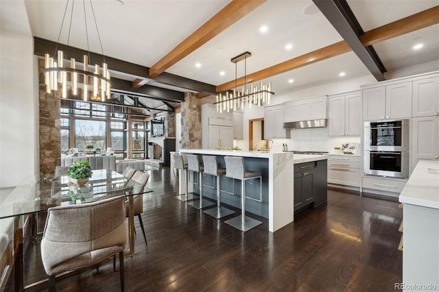 kitchen with tasteful backsplash, dark wood finished floors, stainless steel appliances, and light countertops