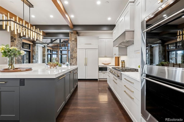 kitchen with beam ceiling, appliances with stainless steel finishes, dark wood-type flooring, and gray cabinetry