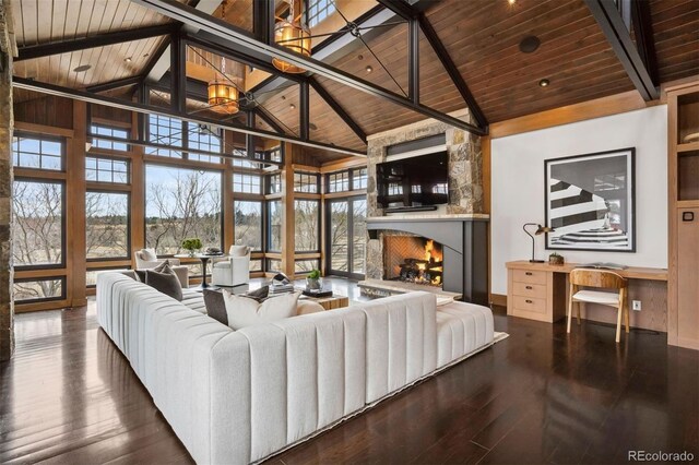 living room with wooden ceiling, hardwood / wood-style flooring, beamed ceiling, a stone fireplace, and high vaulted ceiling