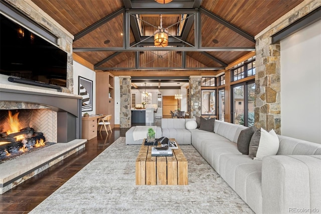 living room with wood ceiling, dark wood-style flooring, an inviting chandelier, a fireplace, and high vaulted ceiling