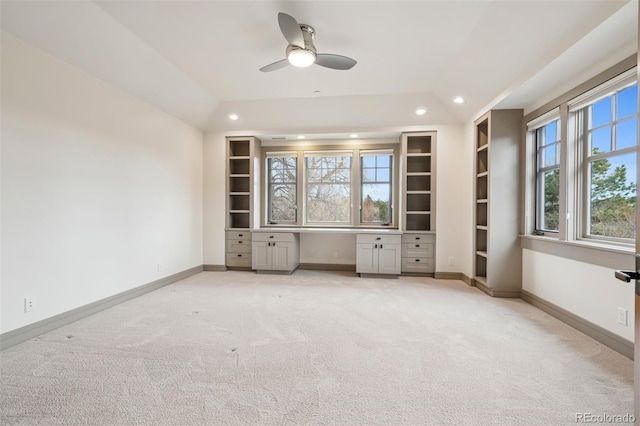 unfurnished office featuring light carpet, baseboards, built in desk, and recessed lighting