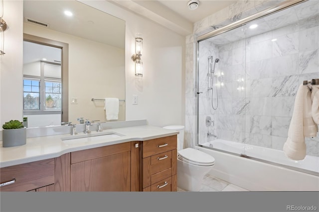 full bath featuring marble finish floor, shower / bath combination with glass door, visible vents, toilet, and vanity