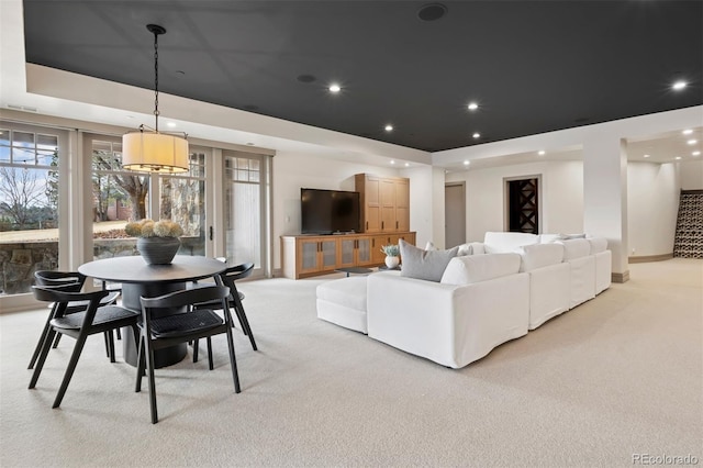 living room featuring recessed lighting, baseboards, light colored carpet, and a tray ceiling