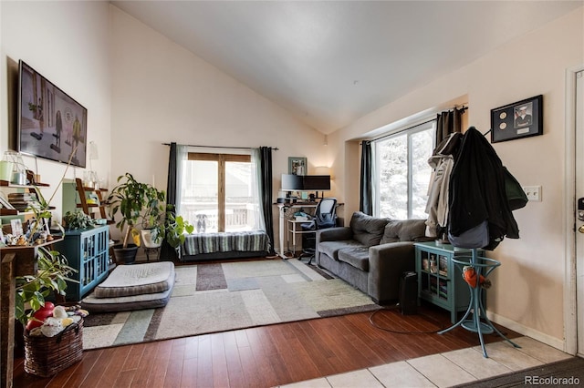 living room with plenty of natural light, high vaulted ceiling, and light wood-type flooring