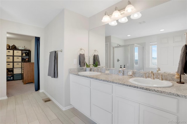 bathroom with a shower with door and vanity