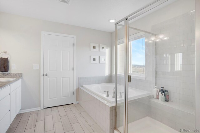 bathroom featuring plus walk in shower and vanity