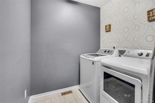 laundry area featuring light tile patterned floors and washer and clothes dryer