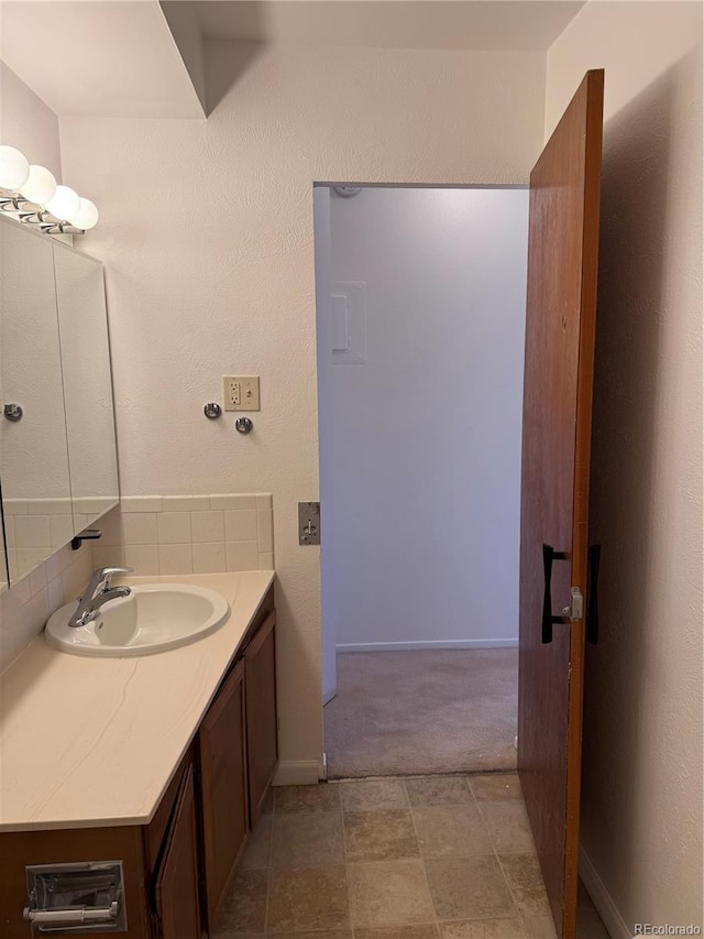 bathroom featuring backsplash, vanity, and baseboards