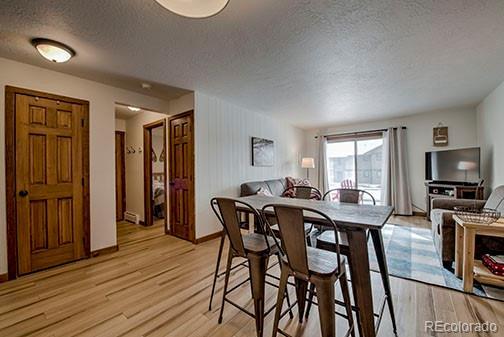 1143 Straight Creek Dr Unit H103, Dillon, CO 80435 - dining area featuring light wood finished floors, baseboards, and a textured ceiling