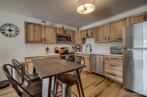 1143 Straight Creek Dr Unit H103, Dillon, CO 80435 - kitchen featuring light wood finished floors, stainless steel appliances, light countertops, and a sink