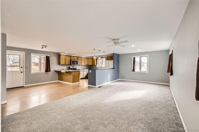 unfurnished living room with baseboards, a wealth of natural light, recessed lighting, and light colored carpet