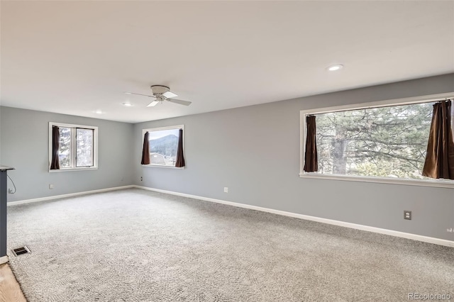 empty room with recessed lighting, baseboards, carpet flooring, ceiling fan, and visible vents