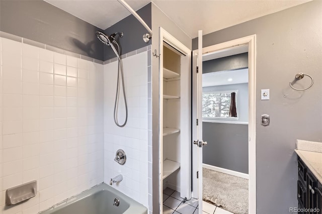 bathroom featuring tile patterned floors, baseboards, vanity, and washtub / shower combination