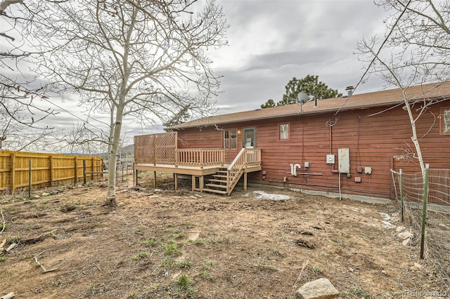 back of property with a deck and fence