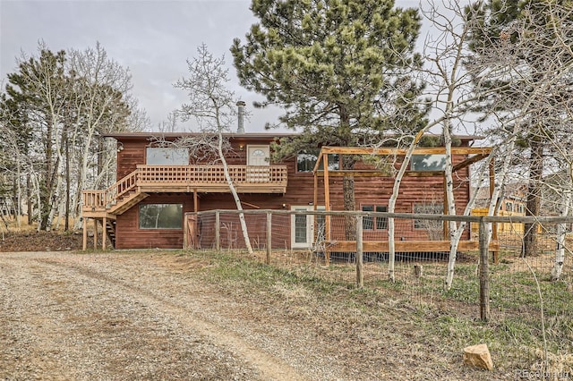 rear view of property with stairs and a wooden deck