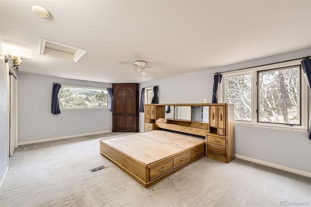 bedroom featuring light colored carpet, attic access, baseboards, and a ceiling fan