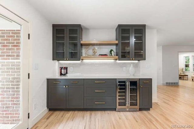 4 Doral Ln, Littleton, CO 80123 - indoor dry bar featuring wine cooler, light wood-type flooring, and decorative backsplash