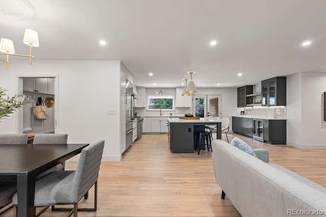 4 Doral Ln, Littleton, CO 80123 - kitchen with light countertops, light wood-style flooring, recessed lighting, a center island, and glass insert cabinets