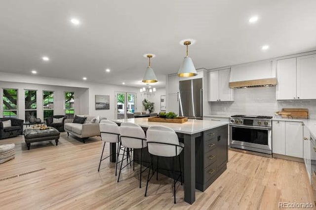 4 Doral Ln, Littleton, CO 80123 - kitchen featuring high end stove, refrigerator, custom range hood, a center island, and white cabinets