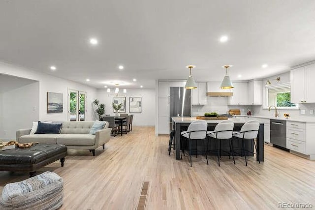 4 Doral Ln, Littleton, CO 80123 - kitchen with stainless steel appliances, recessed lighting, light countertops, a breakfast bar area, and white cabinetry