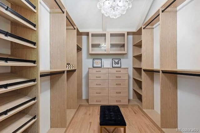 4 Doral Ln, Littleton, CO 80123 - spacious closet featuring light wood finished floors, a chandelier, and lofted ceiling