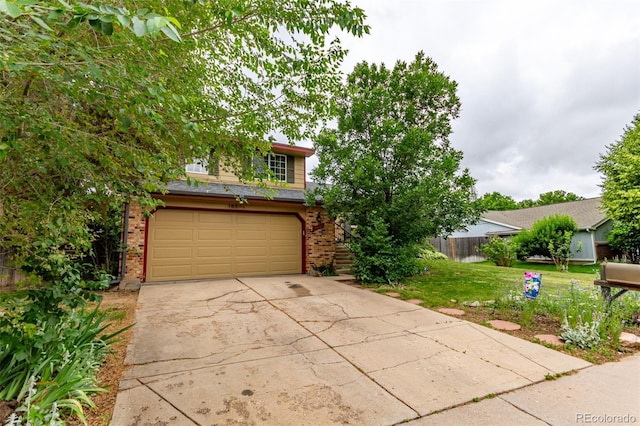 18206 E Loyola Dr, Aurora, CO 80013 - obstructed view of property with brick siding, an attached garage, and driveway