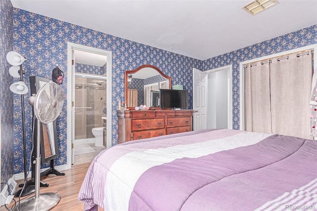 18206 E Loyola Dr, Aurora, CO 80013 - bedroom featuring wood finished floors, wallpapered walls, and ensuite bath