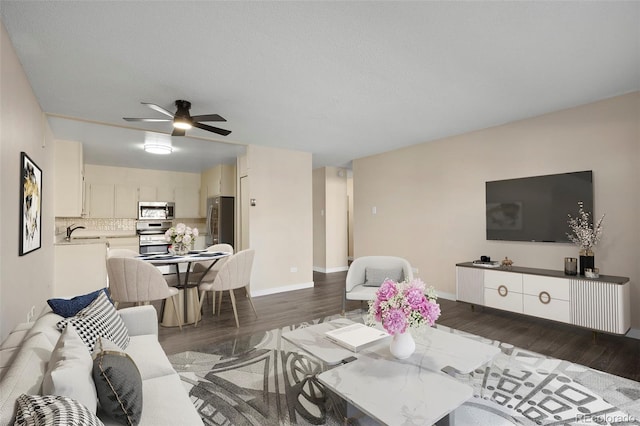 living room featuring dark wood-type flooring, ceiling fan, sink, and a textured ceiling