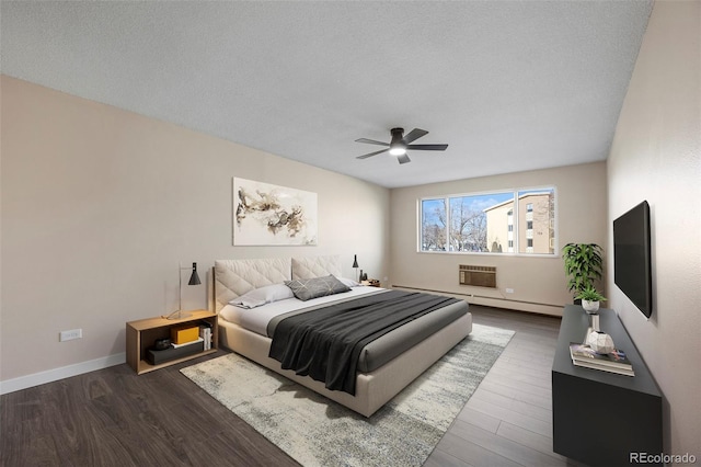 bedroom with an AC wall unit, dark wood-type flooring, a textured ceiling, and ceiling fan