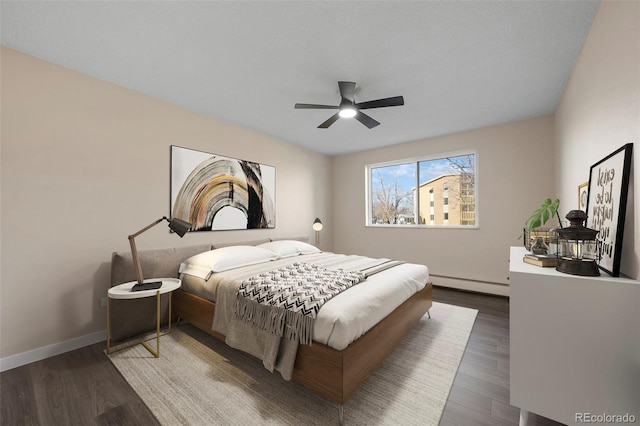 bedroom featuring hardwood / wood-style flooring, a baseboard radiator, and ceiling fan