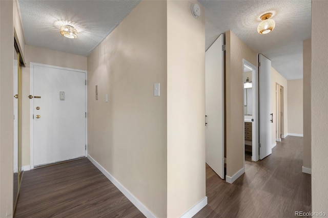 hallway featuring dark hardwood / wood-style flooring and a textured ceiling