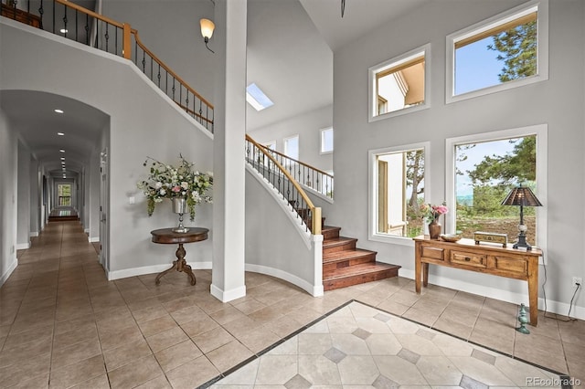 1425 Autumnwood Ln, Evergreen, CO 80439 - tiled foyer featuring a towering ceiling, healthy amount of natural light, stairs, and baseboards